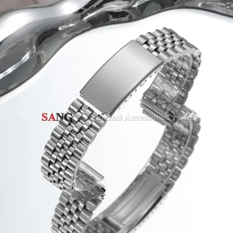 A close-up view of a polished stainless steel watch band with a folding clasp.