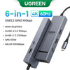 A gray UGREEN 6-in-1 hub featuring HDMI, USB-A, and USB-C ports for high-speed data transfer.