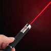 A hand holds an interactive pet training pen emitting a red laser beam against a dark background.