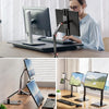 A person is using an adjustable multi-angle monitor stand to position a laptop or monitor for viewing.