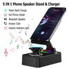 A black phone speaker stand and charger device shown next to a smartphone displaying various features.