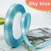 Roll of sky blue satin ribbon with gold edge for crafting or decoration