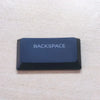 A dark blue and black Backspace keycap for a keyboard.
