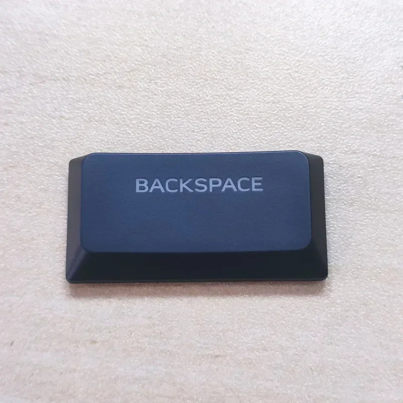 A dark blue and black Backspace keycap for a keyboard.