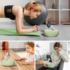 A woman uses a magnetic pillow stand to hold a device while working on a wooden table.