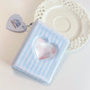 A clear binder with a heart-shaped window is shown next to a white lace-edged plate.