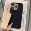 A black polka dot textured phone case with a silver ring is displayed on a white card.