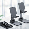 A set of adjustable desktop phone stands designed to hold smartphones and tablets on a white surface.