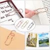 Elegant rose gold metal pen clips used to secure pages in notebooks and journals.