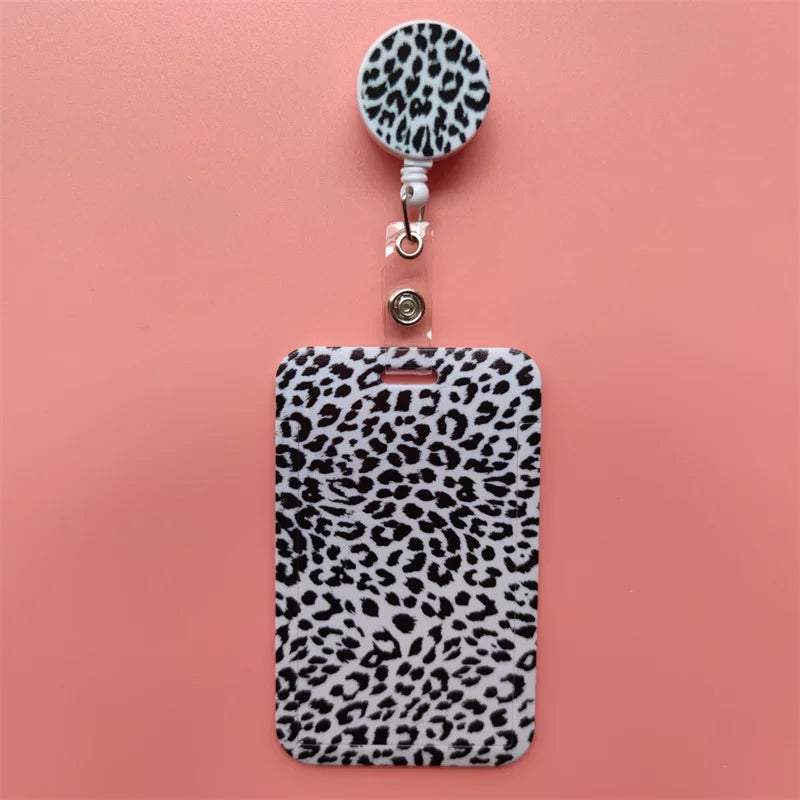 A black leopard print retractable card holder clip with a circular badge holder attached.