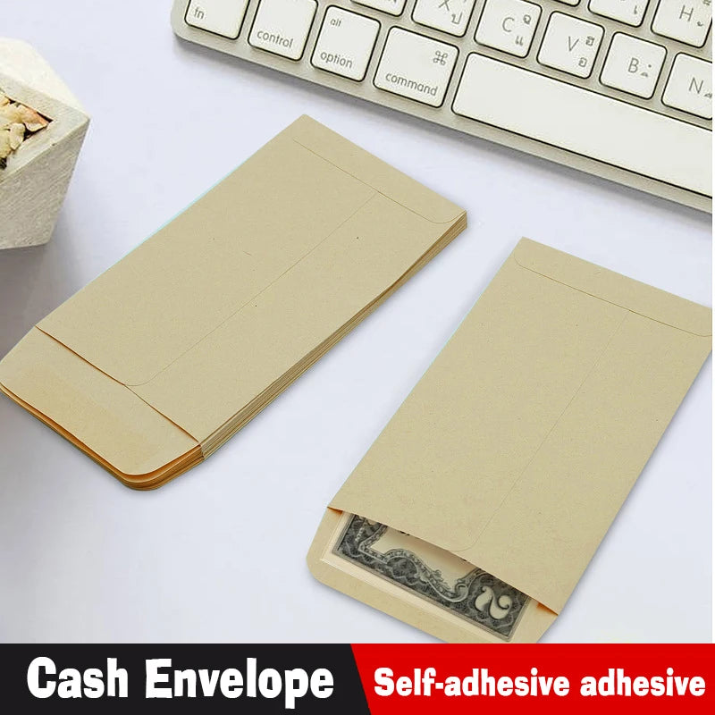 A set of light brown kraft envelopes is shown next to a white keyboard and a small piece of wood.