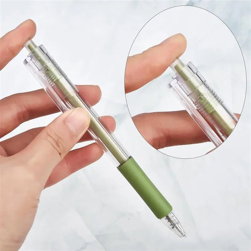 A hand holds a precision utility knife set with green and clear blades against a white background.