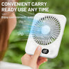 A hand holds a white portable fan, demonstrating its convenient carry and ready-to-use feature.