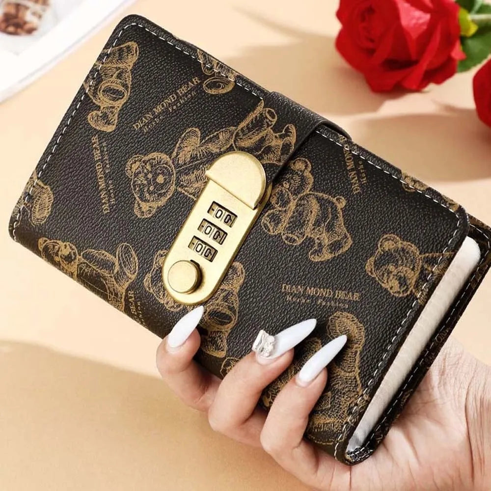 Un carnet budget en faux cuir marron avec motif ours et serrure de sécurité or tenu dans une main.