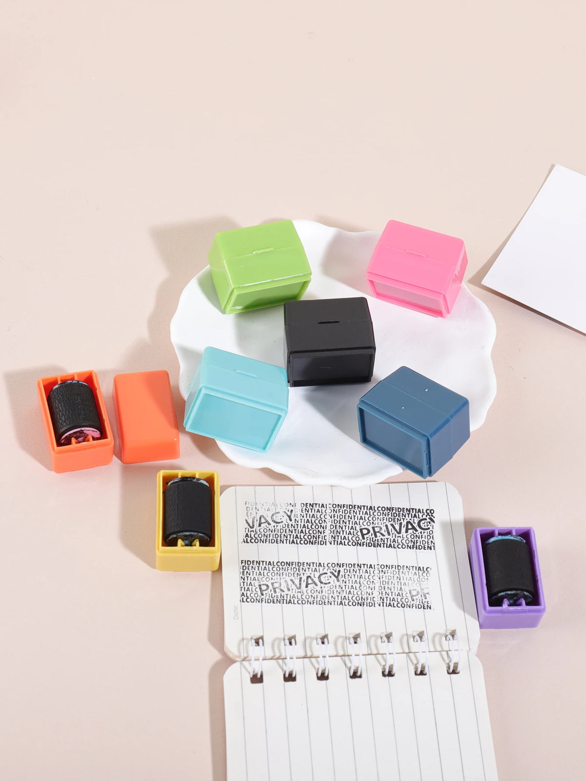 A set of colorful privacy protection roller stamps in various shades of green, pink, black, and blue are displayed on a white