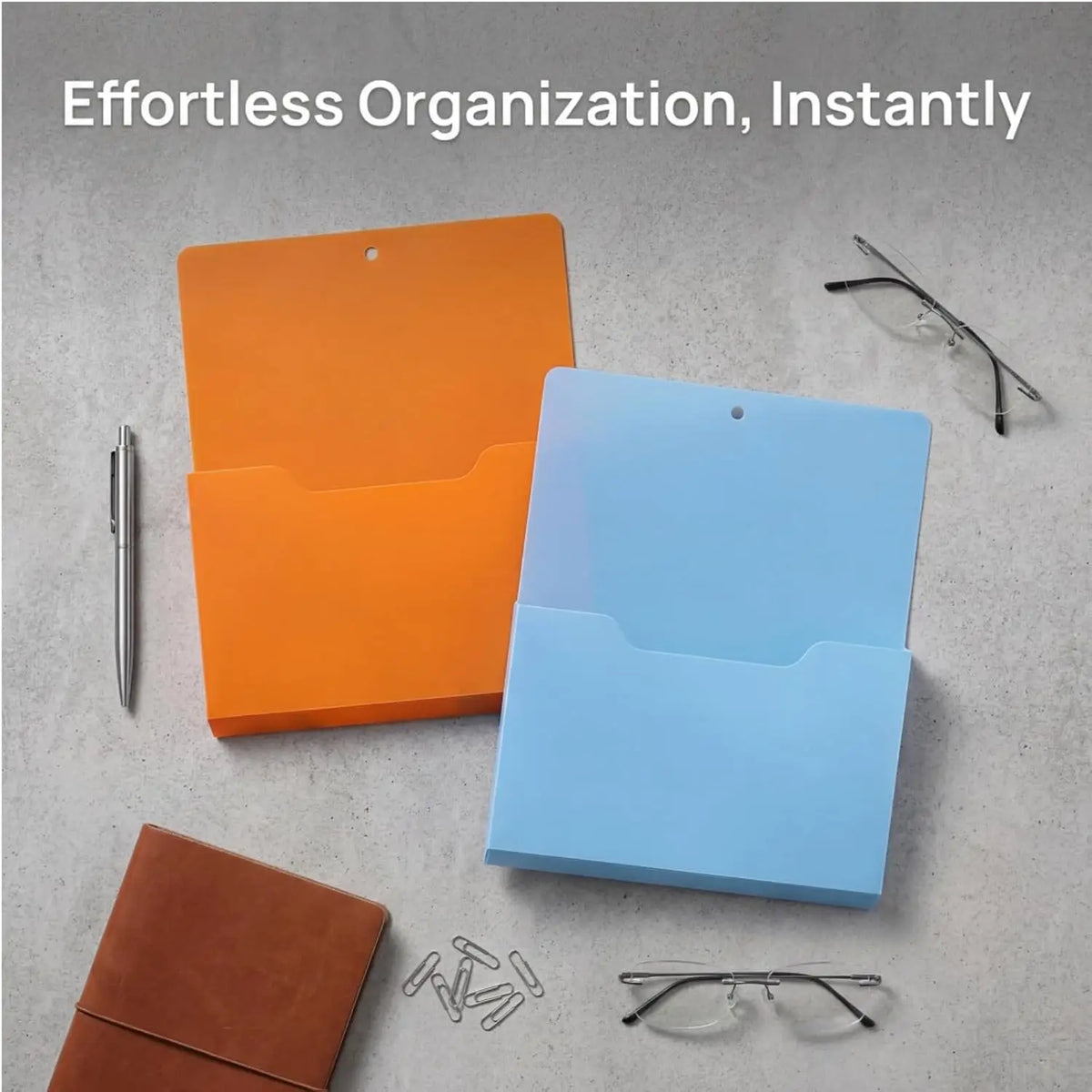 Two orange and blue magnetic document file holders with pens and eyeglasses displayed on a gray surface.