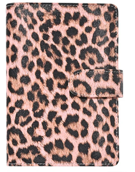 A pink leopard print A6 binder with a black elastic closure.
