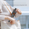 A person is holding a black AI face tracking smartphone tripod with Bluetooth remote in a white tote bag.