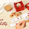 A collection of red and kraft paper note cards and envelopes with hearts, arranged on a beige fabric surface.