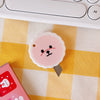 A pink cat paw-shaped mini cutter is placed on a yellow and white checkered surface next to a pink box.