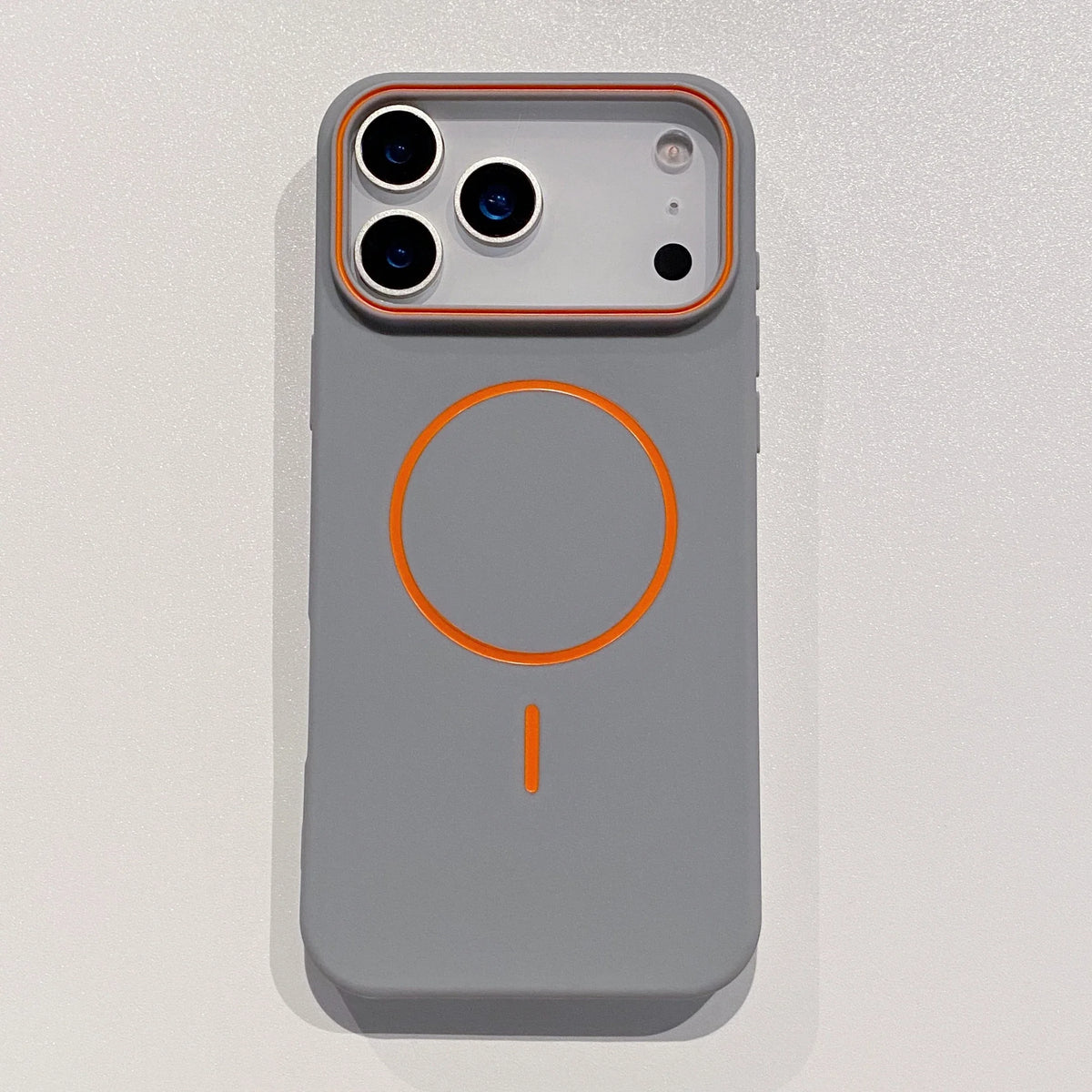 A gray phone case with an orange circular design and a camera module visible on the back.