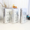 A set of clear plastic binders displaying savings goals like 2.5K, 5K, and 10K with floral illustrations.