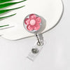 A clear retractable ID badge holder with a floral pull buckle featuring pink and white flowers.