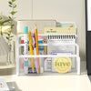 A white metal mesh desk file organizer holding various stationery and a daily planner.