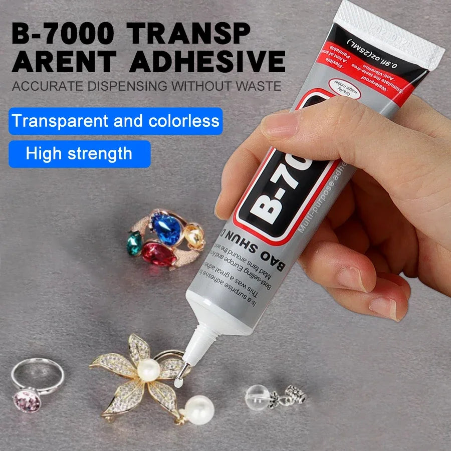 A hand holds a tube of B-700 transparent and colorless adhesive for jewelry making, with various finished pieces nearby.