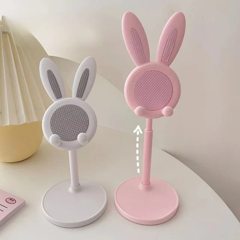A pink rabbit-shaped mobile phone stand with a white body and pink base.