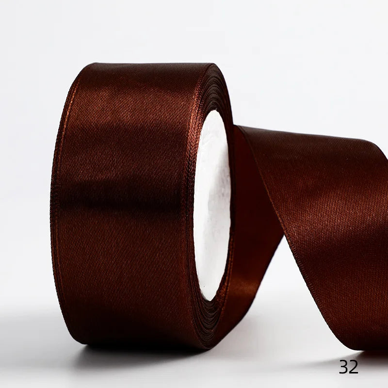 A roll of dark brown satin ribbon used for gift wrapping and DIY crafts.