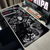 A large black and white Berserk anime mouse pad is displayed on a desk next to a mechanical keyboard and gaming mouse.