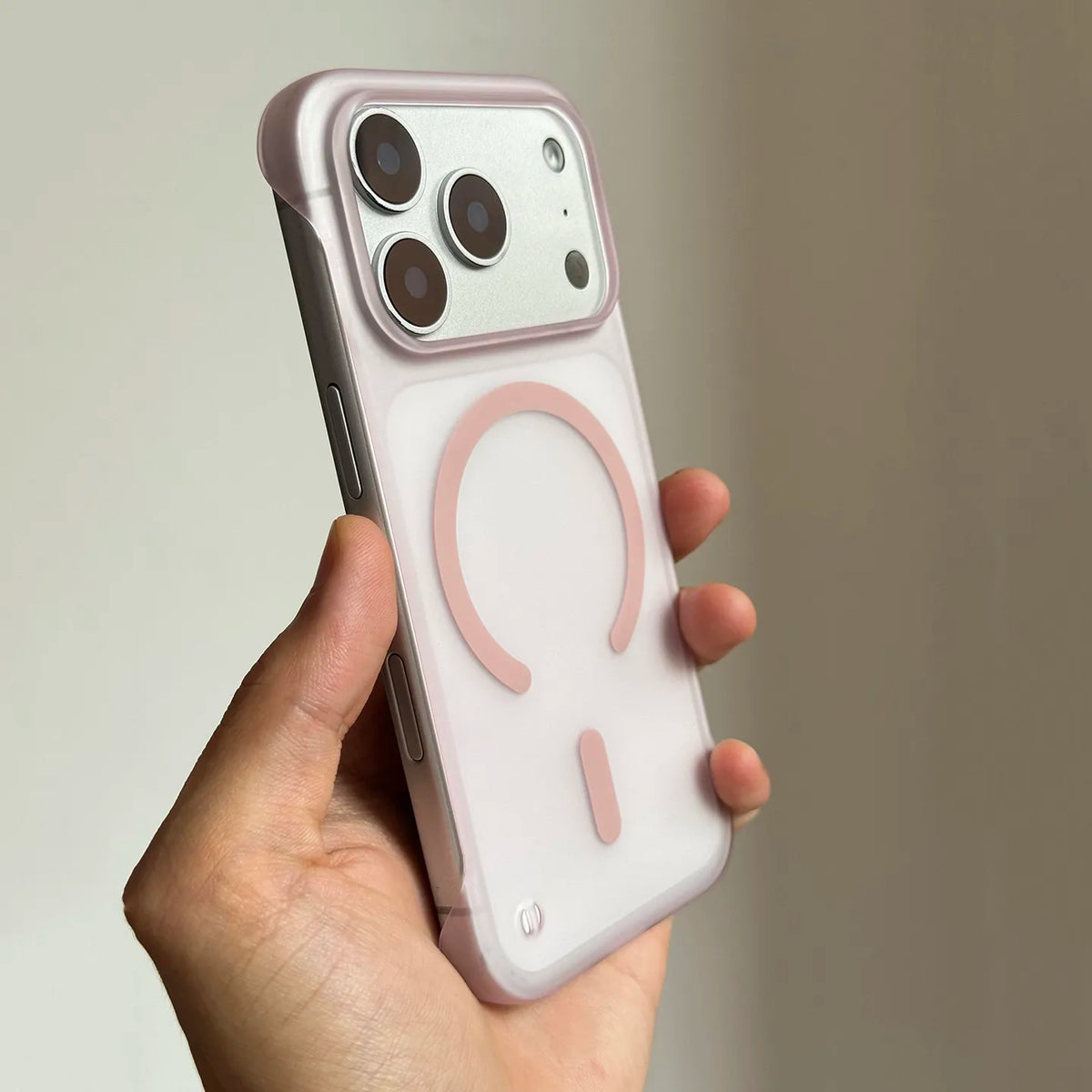 A hand holds a pink Slim Magnetic Phone Case for iPhone Magsafe with a circular cutout design.