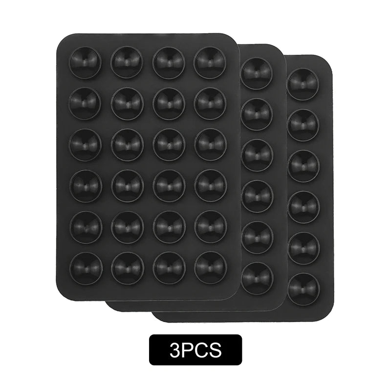 A pack of nine black silicone suction phone mounts arranged in a grid.