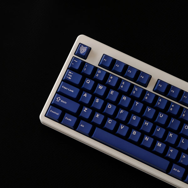 A close-up view of a dark blue PBT keycap set for a mechanical keyboard.