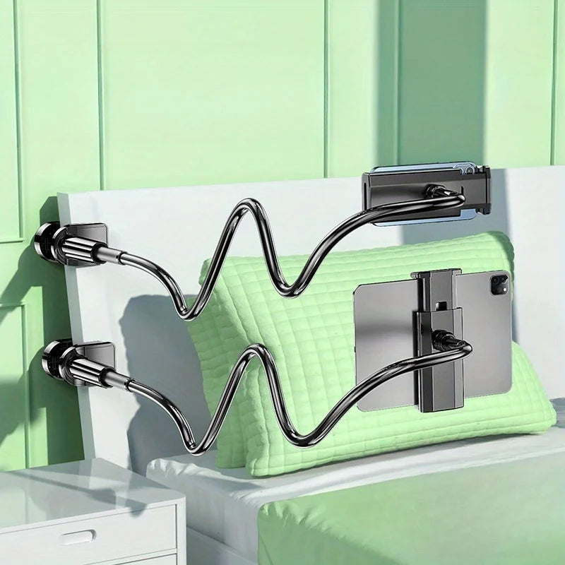A silver rotating tablet and phone stand with a flexible spiral base resting on a light green surface.