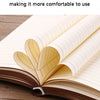 An open notebook with lined pages showing a decorative leaf pattern on the cover, resting on a wooden surface.
