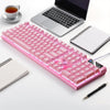A pink low profile wired gaming keyboard with a numpad is displayed next to a laptop and a notebook.