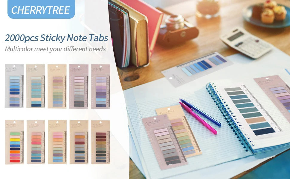 A collection of colorful sticky note tabs and pads displayed on a wooden table next to a notebook and pens.