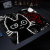 A black cat silhouette design printed on a large mouse pad with a non-slip rubber base.