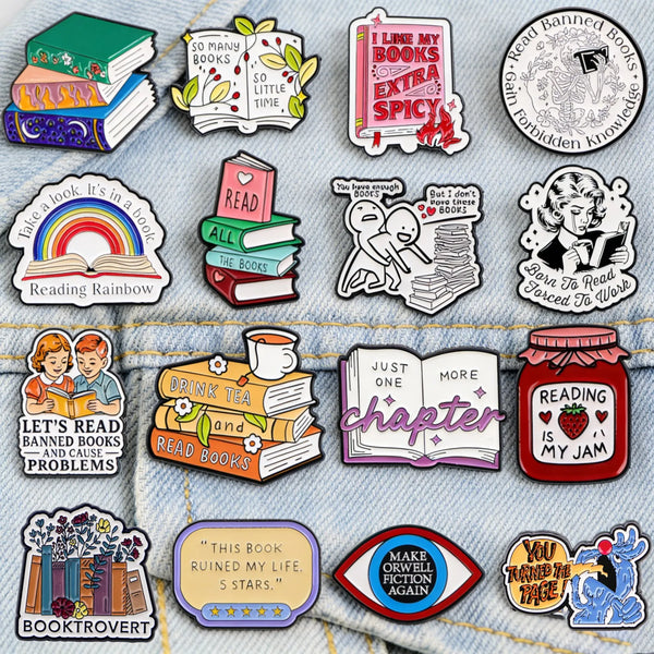 A collection of enamel lapel pins featuring various book-themed designs like rainbows, stacked books, and literary quotes.