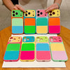 A collection of colorful block acrylic phone cases for an iPhone, arranged in a row.