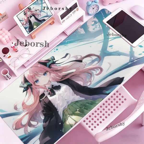A pink mouse pad featuring an anime girl illustration with pink hair and a bow, placed on a desk.