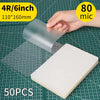 A hand is holding a clear thermal laminating pouch, showing its size and material against a grid background.