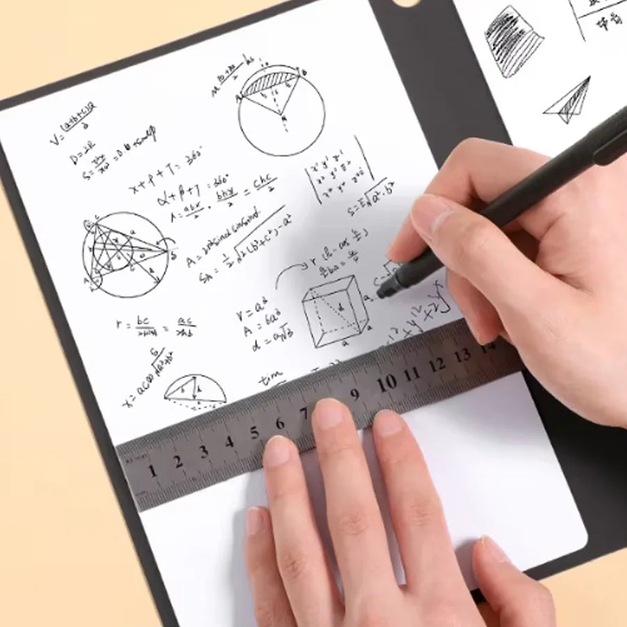 A hand is writing mathematical formulas and diagrams on a white notebook page using a black pen and a ruler.