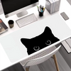 A black silhouette of a cat's head is printed on a white mouse pad placed on a desk.