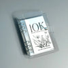 A clear plastic money clip shows the text 10K monthly savings challenge and the name Cin Girl Cash Stufeer