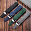 A collection of perforated silicone watch straps in various colors including black, navy blue, dark green, and gray.