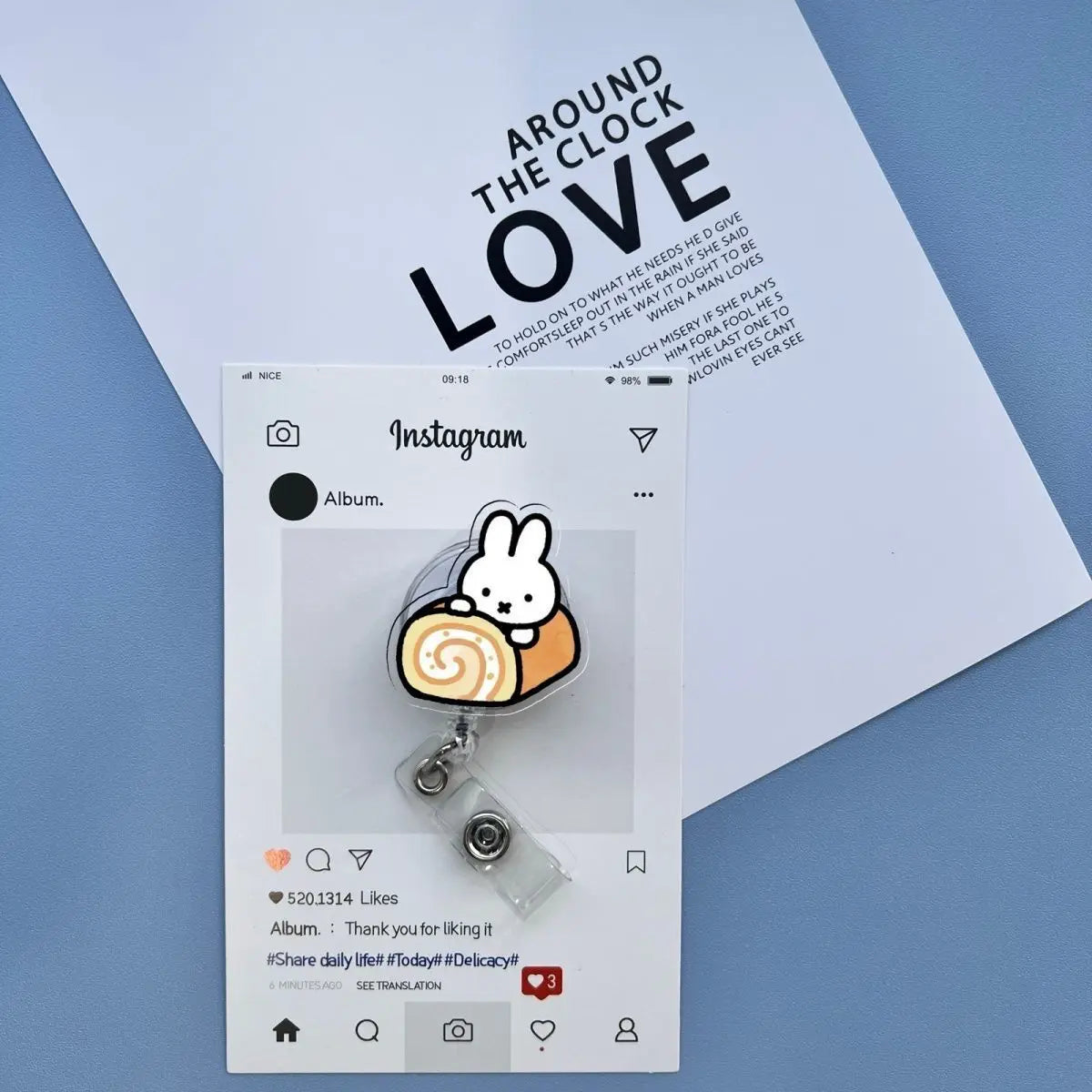 A white Instagram post featuring a Miffy rabbit badge reel attached to a clear clip, set against a light blue background.