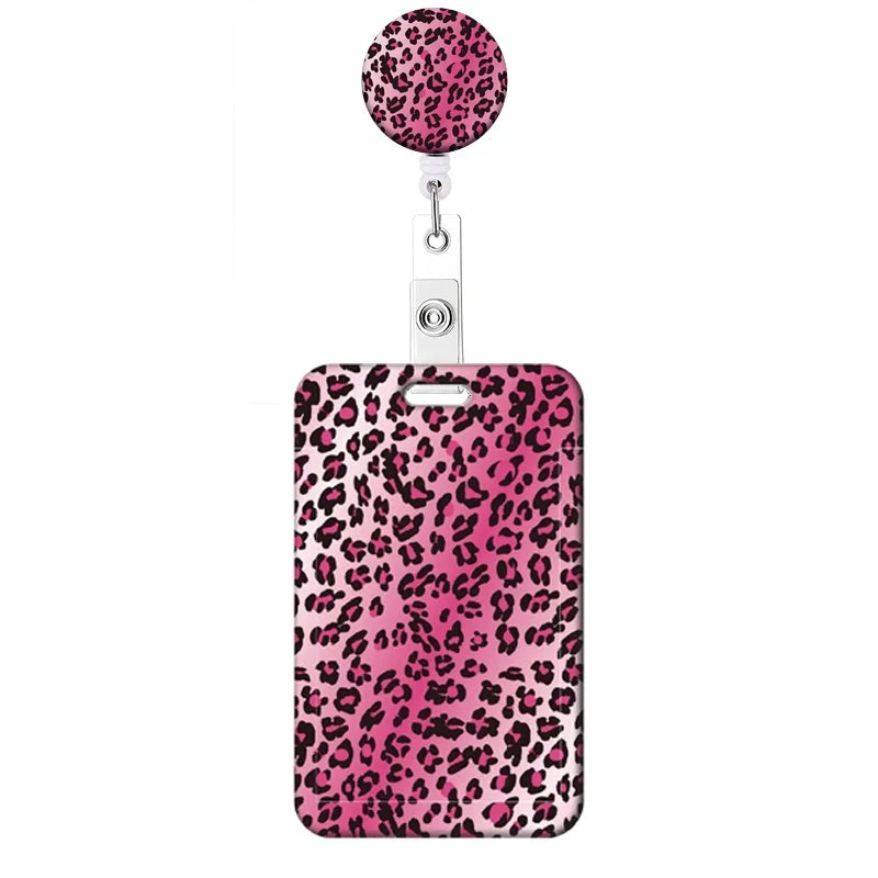 A pink leopard print retractable badge holder with a circular top.